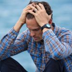 Happiness in Focus: Man in Blue and Brown Plaid Dress Shirt Touching His Hair