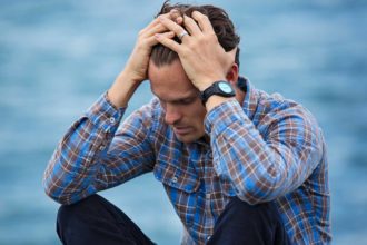 Happiness in Focus: Man in Blue and Brown Plaid Dress Shirt Touching His Hair